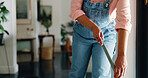 Hands, broom and woman with cleaning in home for dust removal, housekeeping and maintenance. Housework, cleaner and sweeping in house for dirt prevention, hygiene and domestic chores for cleanliness
