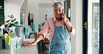 Phone call, cleaning and woman with products in home for contact, networking or communication. Housekeeping, cellphone and mature housewife on mobile conversation by sanitizing supplies in apartment.