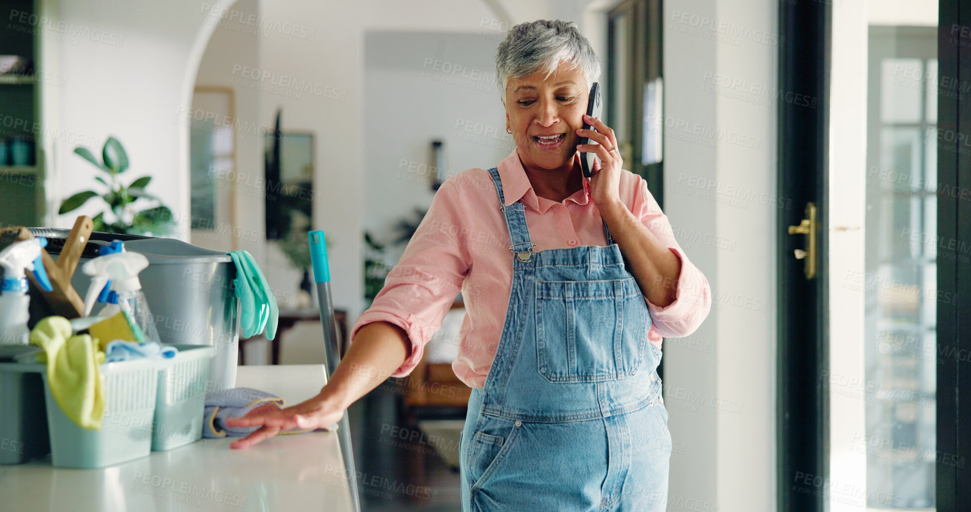 Buy stock photo Phone call, cleaning and woman with products in home for contact, networking or communication. Housekeeping, cellphone and mature housewife on mobile conversation by sanitizing supplies in apartment.