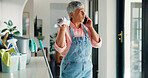 Senior woman, cleaning and argument with phone call for housekeeping or domestic service at home. Female person, maid and cleaner talking on mobile smartphone for disagreement or dirty mess at house