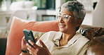 Mature woman, phone and happy on sofa with post, texting and check notification on web in home. Person, smartphone and smile with mobile app, click and relax with social media on couch at apartment