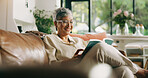 Senior, woman and reading a book in home for cognition, best seller story and retirement hobby. Happy, old person or relax with literature novel on sofa for fantasy fiction, information and knowledge