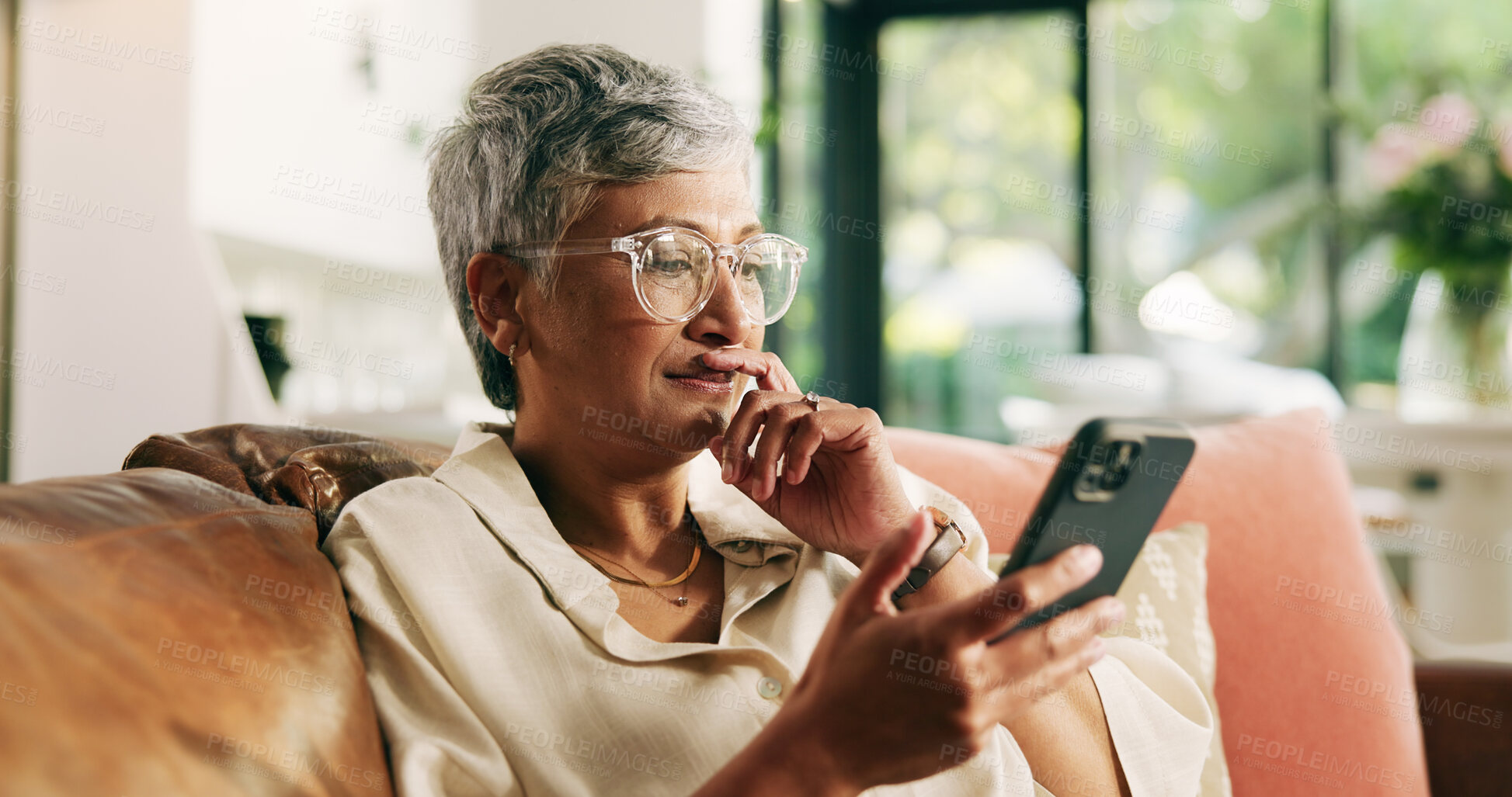Buy stock photo Mature woman, phone and sofa in home with thinking, texting and reading notification on web. Person, smartphone and decision with mobile app, search and post on social media on couch at apartment