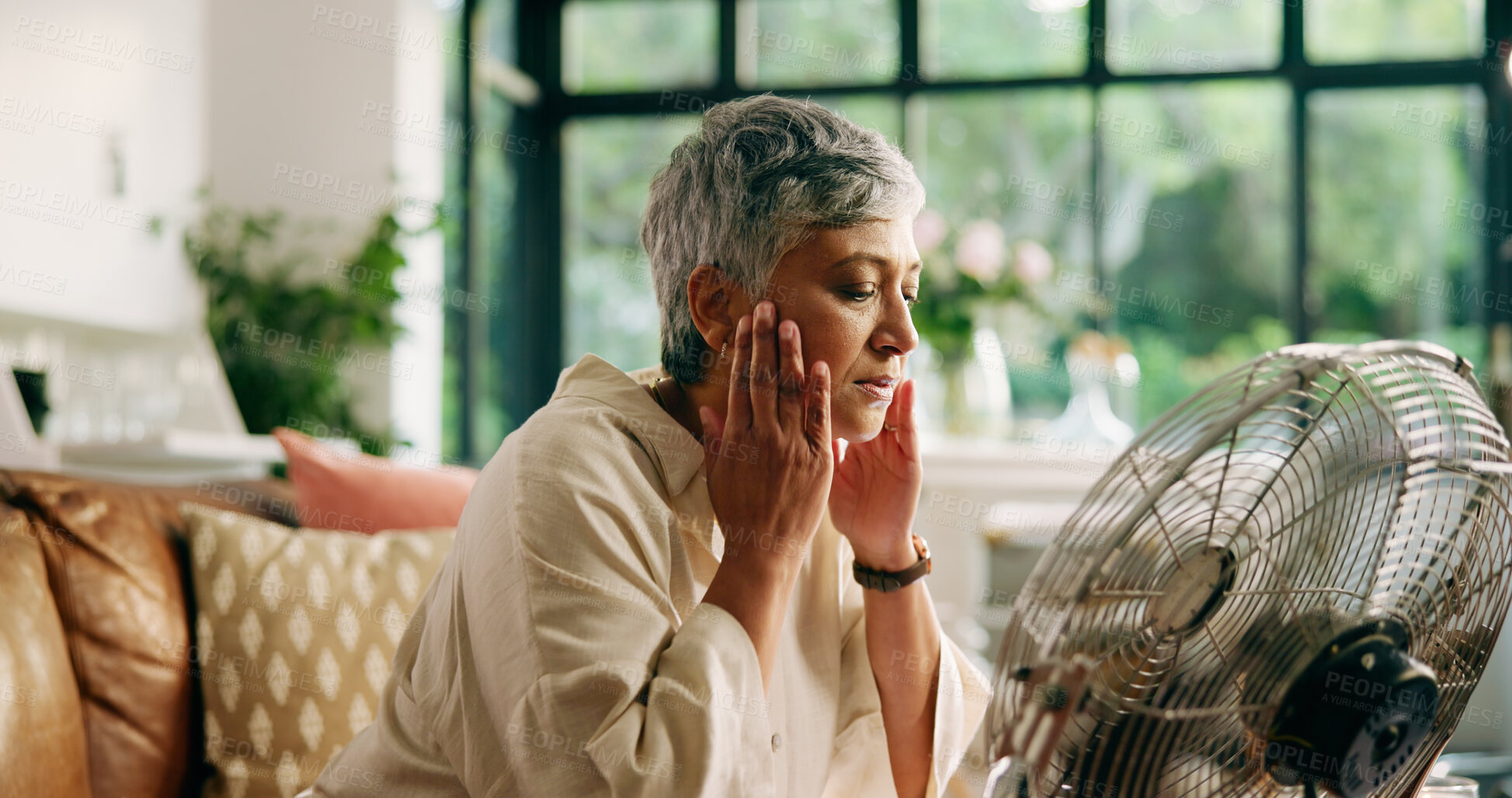 Buy stock photo Senior woman, hot and fan at house for heatwave, air conditioning and menopause symptoms. Elderly person, sweat and electric appliance for cool breeze, warm weather and relief from hormonal condition