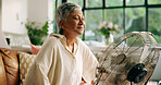 Elderly woman, hot and fan at house for heatwave, air conditioning and menopause symptoms. Senior person, relax and electric appliance for cool breeze, warm weather and relief from hormonal condition
