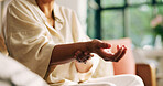 Hands, arthritis and woman with wrist pain on sofa for joint injury, inflammation and massage. Carpal tunnel, person and sprain in home for fibromyalgia and muscle fatigue from osteoporosis disease