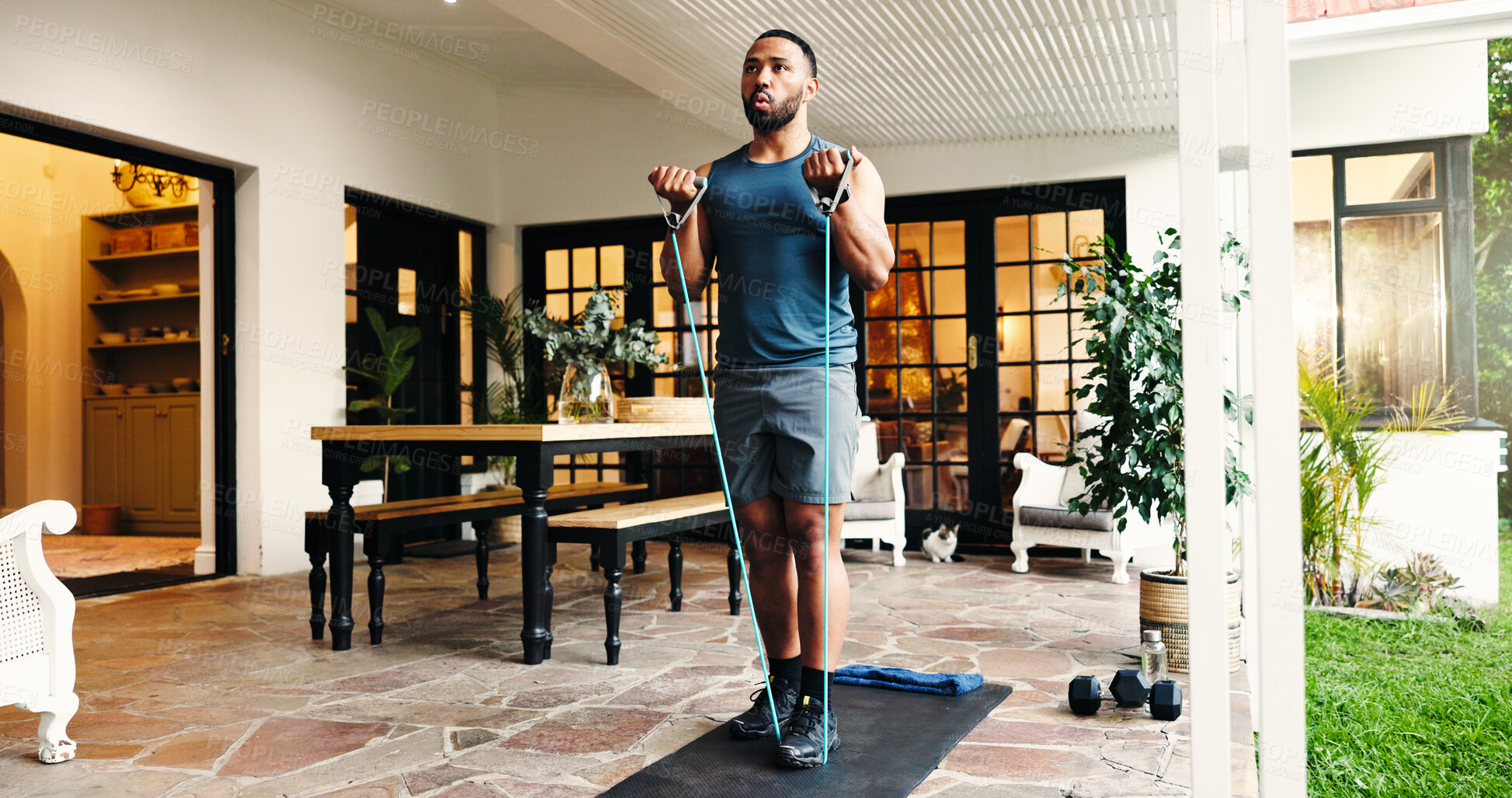 Buy stock photo Man, exercise and training with resistance band, home and equipment for fitness, patio and wellness. Outdoor, athlete and person with routine for muscle strength, house and workout for bodybuilding