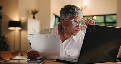 Buy stock photo Home, checking and woman with laptop, glasses and proofreading for editing, evening and serious. Mature person, eyewear and journalist with paperwork, pc and email with remote work and vision