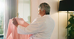 Mature woman, shirt and choice in mirror of bedroom for getting ready, planning clothes and style. Happy, fashion and person in home with blouse for garment decision, outfit selection and start day