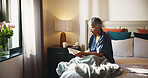 Reading, relax and senior woman with story on bed in home with hobby, literature or knowledge. Smile, fiction and elderly female person in retirement enjoying fantasy book in bedroom of apartment.