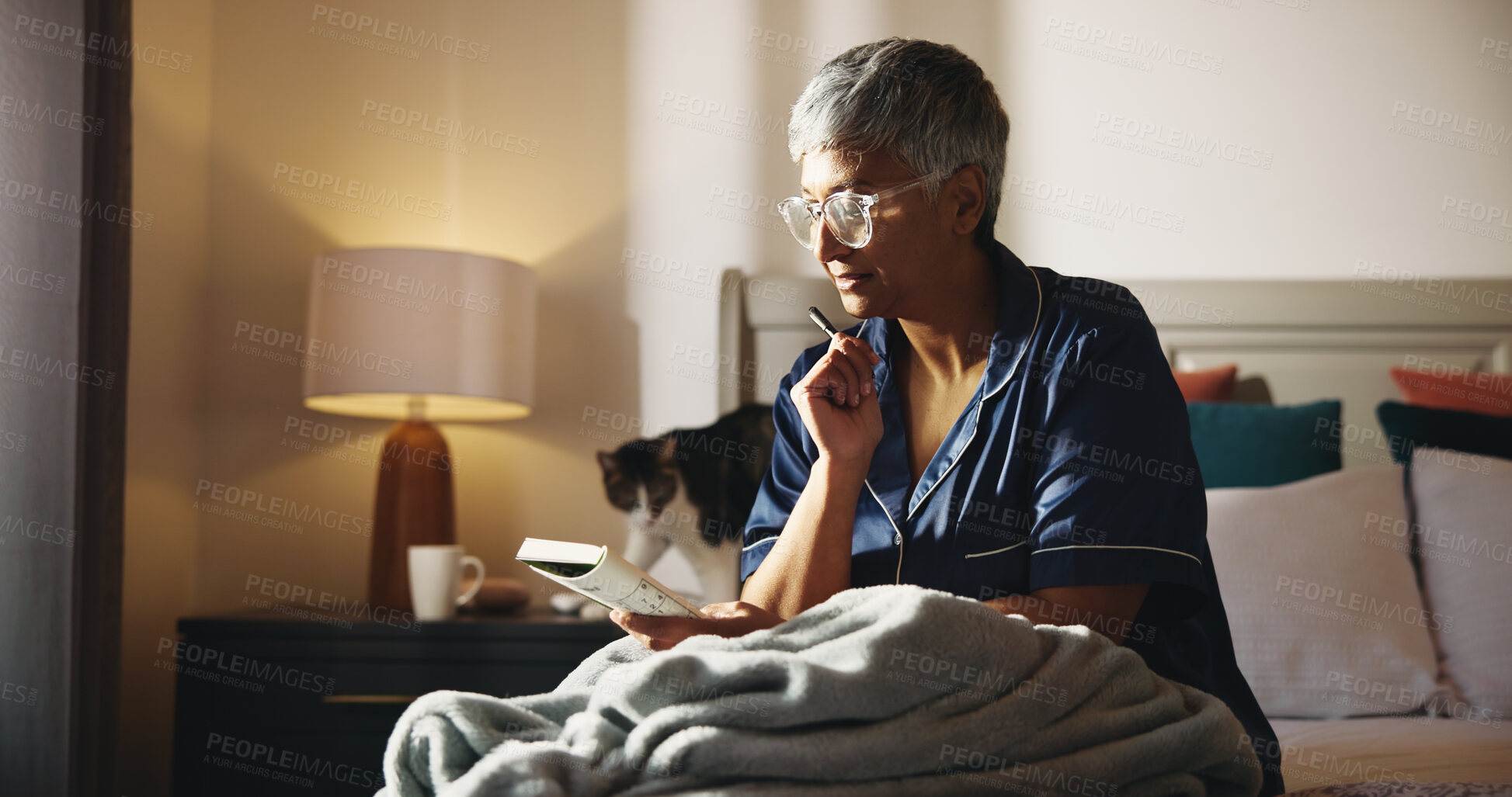 Buy stock photo Thinking, crossword and book with old woman in bed for puzzle, strategy game and reading. Brainstorming, problem solving and solution with senior person in bedroom of home for relax and idea