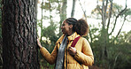 Hiking, forest and african woman touch tree outdoor as naturalist, environmentalist or nature lover. Connection, appreciation or hiker person trekking for adventure, travel and vacation by woods