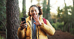 Woman, video call and hiking in forest with smile, wave and social media with adventure in nature. African person, smartphone and influencer in woods on mobile app, live stream or trekking in Nigeria