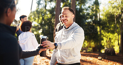 Buy stock photo Marathon, man and share water in forest for fitness, workout and endurance for health. Cardio club, running group and hydration break for competition, practice and team exercise for training together