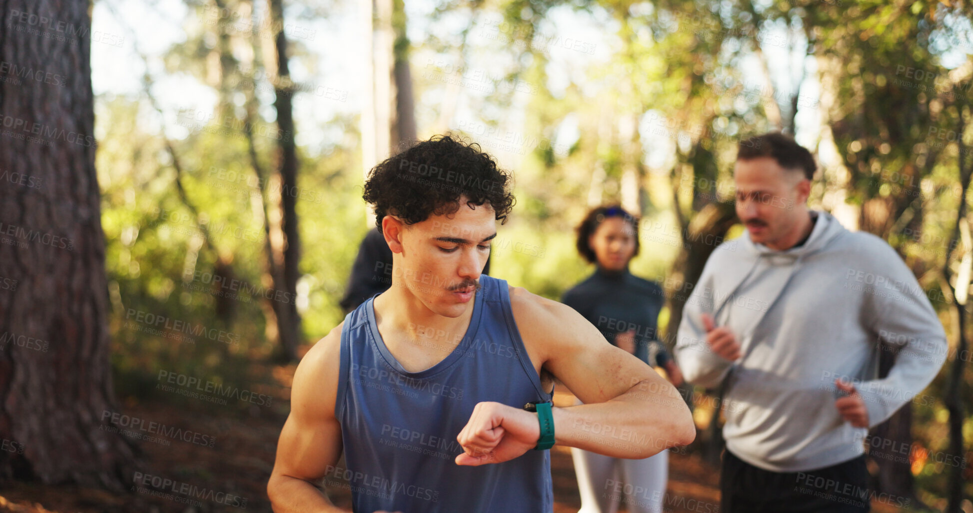 Buy stock photo Marathon, man and check watch in forest for fitness workout, endurance and tracking time. Cardio club, running group and jog together for competition, practice and team exercise for pace training