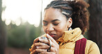African woman, coffee and hiking in forest for cold morning, travel and trekking adventure. Smile, female person and warm beverage for backpacking, enjoy aroma and reflection for sightseeing in woods