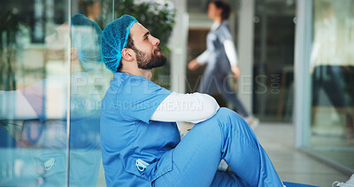 Sad, man and surgeon on floor at hospital with medical mistake, surgery fail and patient loss. Upset, male doctor and stress from bad news, wrong diagnosis and operation error with healthcare burnout