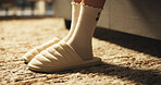 Person, feet and slippers in bedroom at house from sleeping, wake up and morning routine. Closeup, legs and woman with shoes, comfortable footwear and getting ready to start day, bed rest and cozy