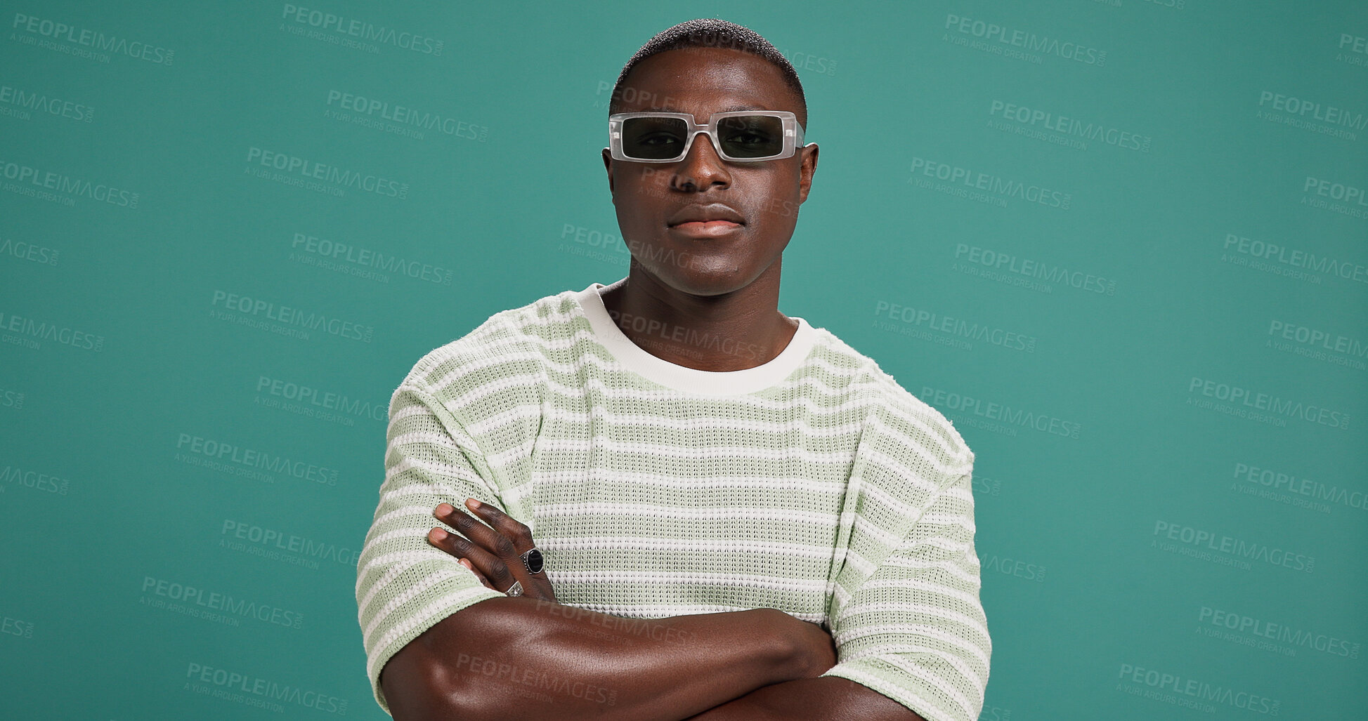 Buy stock photo Black man, fashion and sunglasses with arms crossed, style and confidence on green studio background. Portrait, male person or serious African model with accessory, shades or eyewear on mockup space