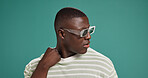 Black man, fashion and sunglasses with cool, style and confidence on green studio background. Gen Z, male person or serious African model with trendy accessory, shades or eyewear on mockup space