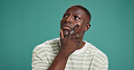 Fashion, thinking and planning with black man in studio for reflection, brainstorming and style choice. Idea, clothes decision and inspiration with person on green background for space and vision