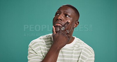 Buy stock photo Fashion, thinking and planning with black man in studio for reflection, brainstorming and style choice. Idea, clothes decision and inspiration with person on green background for space and vision