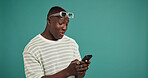 Phone, laugh and black man in studio for social media, text and reading meme with gif. Mobile, online chat and happy model on app for news, funny video and play game on background with mockup space
