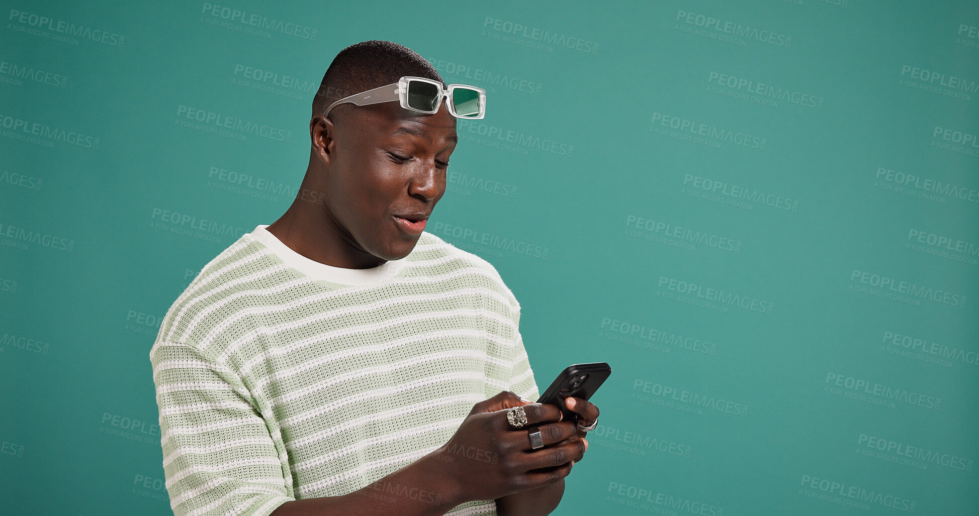 Buy stock photo Phone, laugh and black man in studio for social media, text and reading meme with gif. Mobile, online chat and happy model on app for news, funny video and play game on background with mockup space