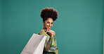Portrait, happy and woman with shopping bag, studio or discount for fashion, pride and mockup space. Green background, shopper and African person with products on sale, smile and customer with gift