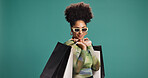 Confident, happy and woman with shopping bag, studio or discount for fashion, mockup space and gift. Green background, shopper and African person with products on sale, smile and customer with shades