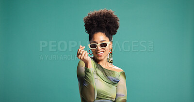 Buy stock photo Heart, sunglasses and face of woman in studio with trendy style, clothes and outfit. Love emoji, fashion and portrait of person with accessories and confidence, pride and smile on green background