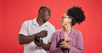Buy stock photo Happy couple, laughing or meme with phone in studio for social media or fashion on red background. Online post, notification or people with smile or mobile app for chat, funny joke and connection