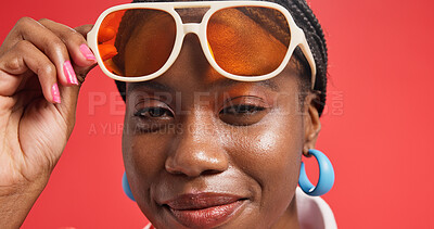 Buy stock photo Black woman, portrait and sunglasses with makeup in studio for fashion on red background. Face, female person or African model with smile or swag for beauty cosmetics, style or cool accessories