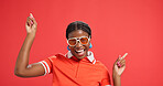 Happy, fashion and black woman pointing in studio for discount news, announcement and sale. Excited, gesture and portrait of person with trendy clothes, sunglasses and cool outfit on red background