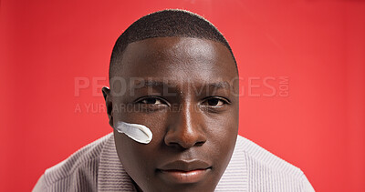 Buy stock photo Apply, beauty or portrait of black man with face cream for skincare, antiaging or facial glow. Space, red background or African model in studio with moisturizer for lotion, sunscreen cosmetics or SPF