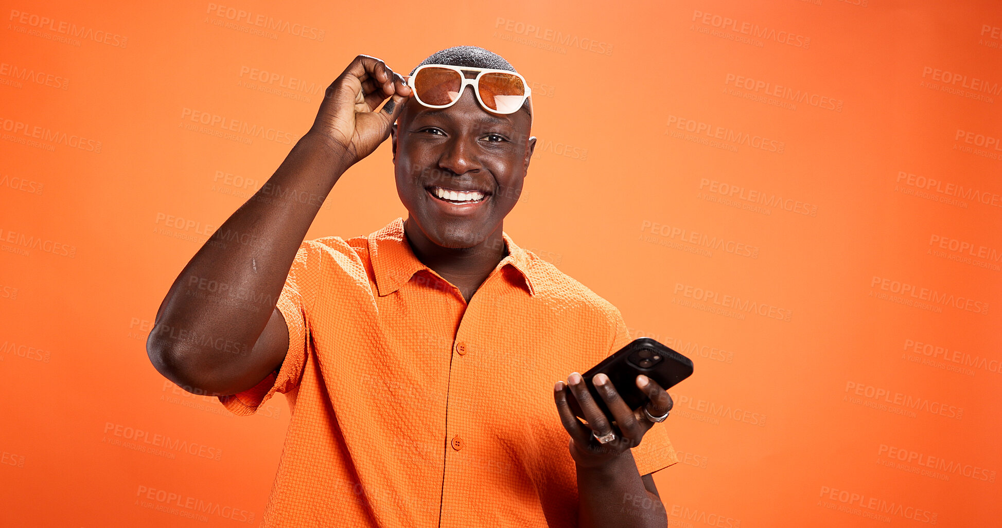 Buy stock photo Space, fashion or happy man with phone in portrait for discount news, sale or bargain deal. Studio, notification or cool person on orange background for trendy sunglasses, confidence or clothes offer