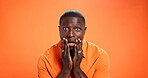 Studio, man and surprised by news, portrait or reaction for gossip, orange background or expression. Mockup space, black person and shocked by rumor, wow and listening to announcement in Kenya