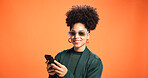 Space, fashion or happy woman with phone in studio for discount news, sale or bargain deal. Mockup, notification or cool person on orange background for trendy sunglasses, confidence or clothes offer