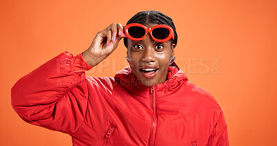 Buy stock photo Portrait, surprise and black woman in studio, sunglasses and announcement on orange background. Facial expression, shocked and African person with shades, discount deal and crazy sale with accessory