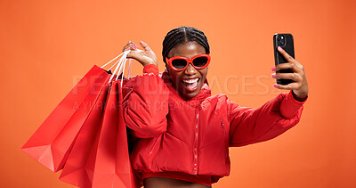 Buy stock photo Selfie, smile and woman with shopping bag, studio and discount for fashion, profile picture and web. Orange background, shopper and black person with giveaway, photography and post on social media