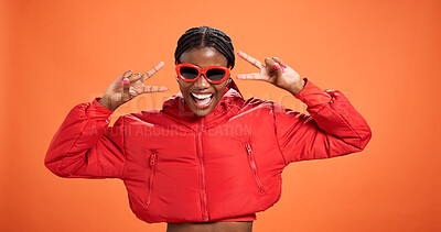 Buy stock photo Sunglasses, excited and black woman with peace sign for fashion, style or trendy. Happy African model, studio or v hand gesture for victory symbol, emoji or cool influencer laugh on orange background