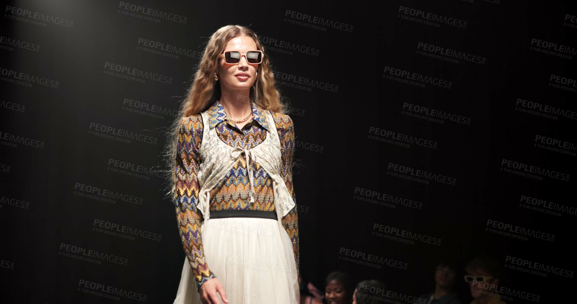 Buy stock photo Woman, model and walking on catwalk with style, confidence or showcase with audience. Fashion, sunglasses and person at black background space with designer clothing, brand ambassador or runway event