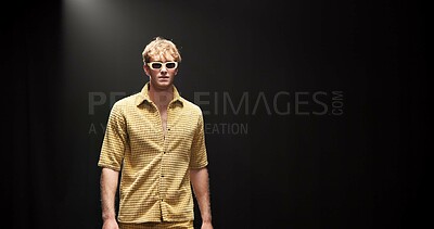 Buy stock photo Fashion, runway and walking with man in studio for designer showcase, clothes presentation and event. Wardrobe launch, luxury brand and collection with model on stage with black background space