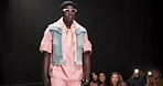 Fashion designer, runway and walking with black man in studio for showcase, clothes presentation and event. Wardrobe launch, luxury brand and collection with model on stage with dark background space