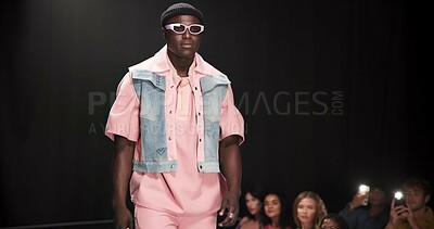Buy stock photo Fashion designer, runway and walking with black man in studio for showcase, clothes presentation and event. Wardrobe launch, luxury brand and collection with model on stage with dark background space