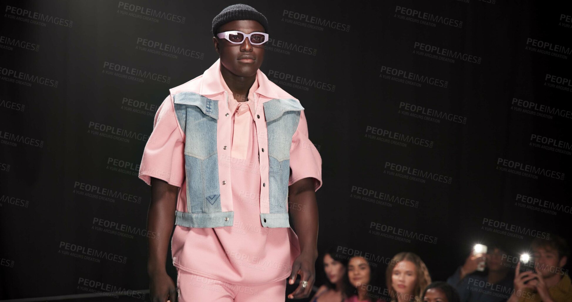 Buy stock photo Fashion designer, runway and walking with black man in studio for showcase, clothes presentation and event. Wardrobe launch, luxury brand and collection with model on stage with dark background space
