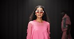 Woman, model and portrait on catwalk with fashion, confidence or posing for showcase. Style, sunglasses and person at black background space with designer clothing, brand ambassador or runway event