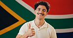 South Africa, flag and portrait of happy man with thumbs up, confidence and country loyalty. Rainbow nation, heritage and proud person with African symbol for nationality, citizenship or patriotism