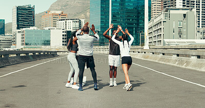 Buy stock photo Runner, group and high five in city for fitness, motivation and support for achievement on bridge. People, men and women in circle with celebration, success and exercise with goals on urban street