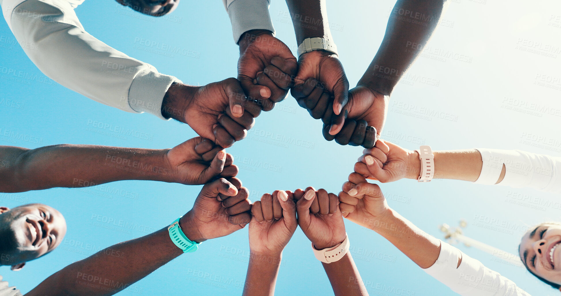 Buy stock photo Outdoor, group and fist bump for sports, celebration or collaboration for fitness, hands and circle. Blue sky, team and gesture for agreement, low angle and community with support, unity and success